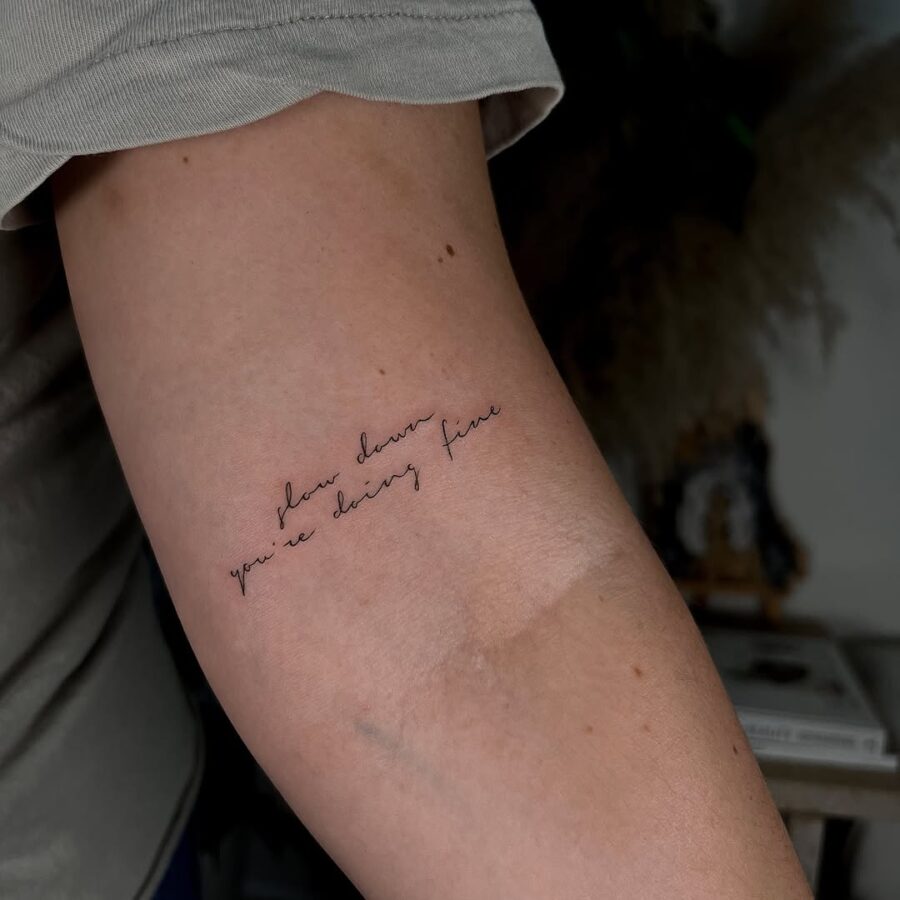 Elegant script tattoo with a motivational quote Tattoo on skin