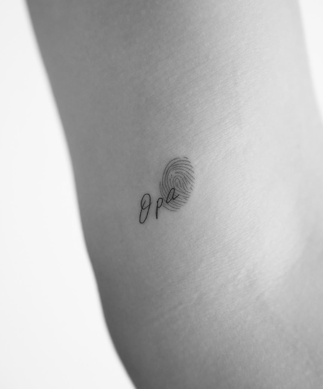 Minimalist fingerprint with elegant script Tattoo on skin