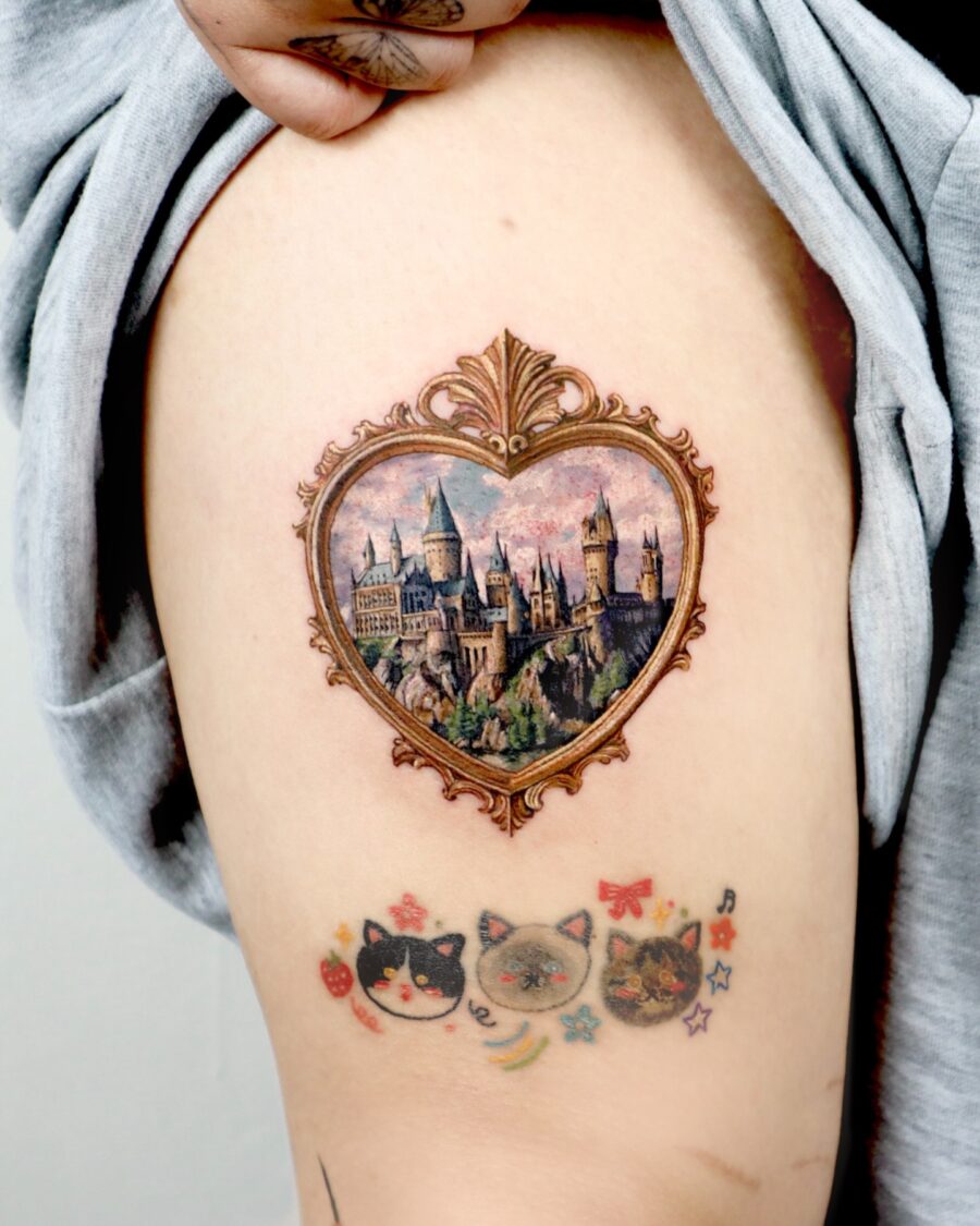 Beautiful Hogwarts castle in ornate heart frame Tattoo on skin