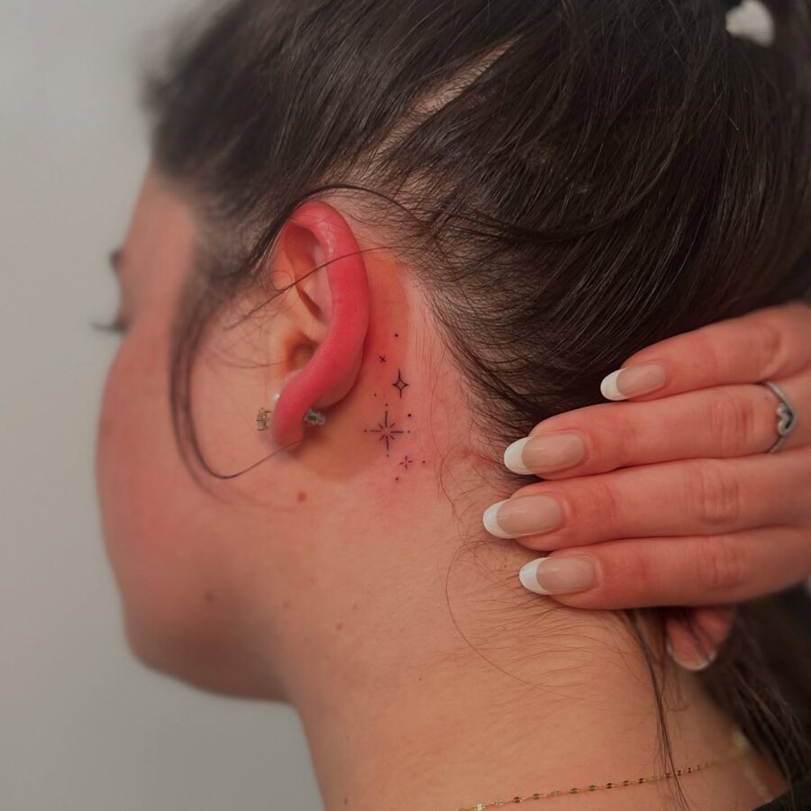 Delicate stars tattoo hidden behind the ear Tattoo on skin