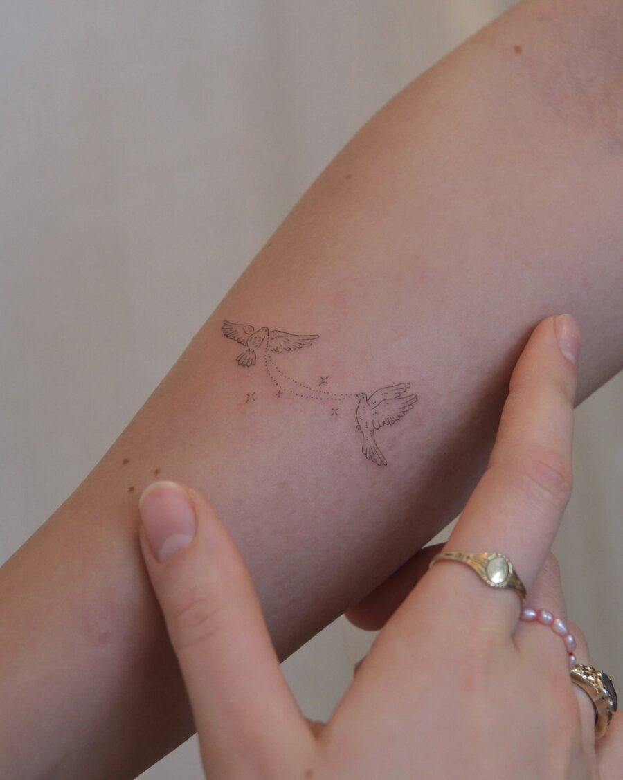 Elegant birds in subtle flight tattoo design Tattoo on skin