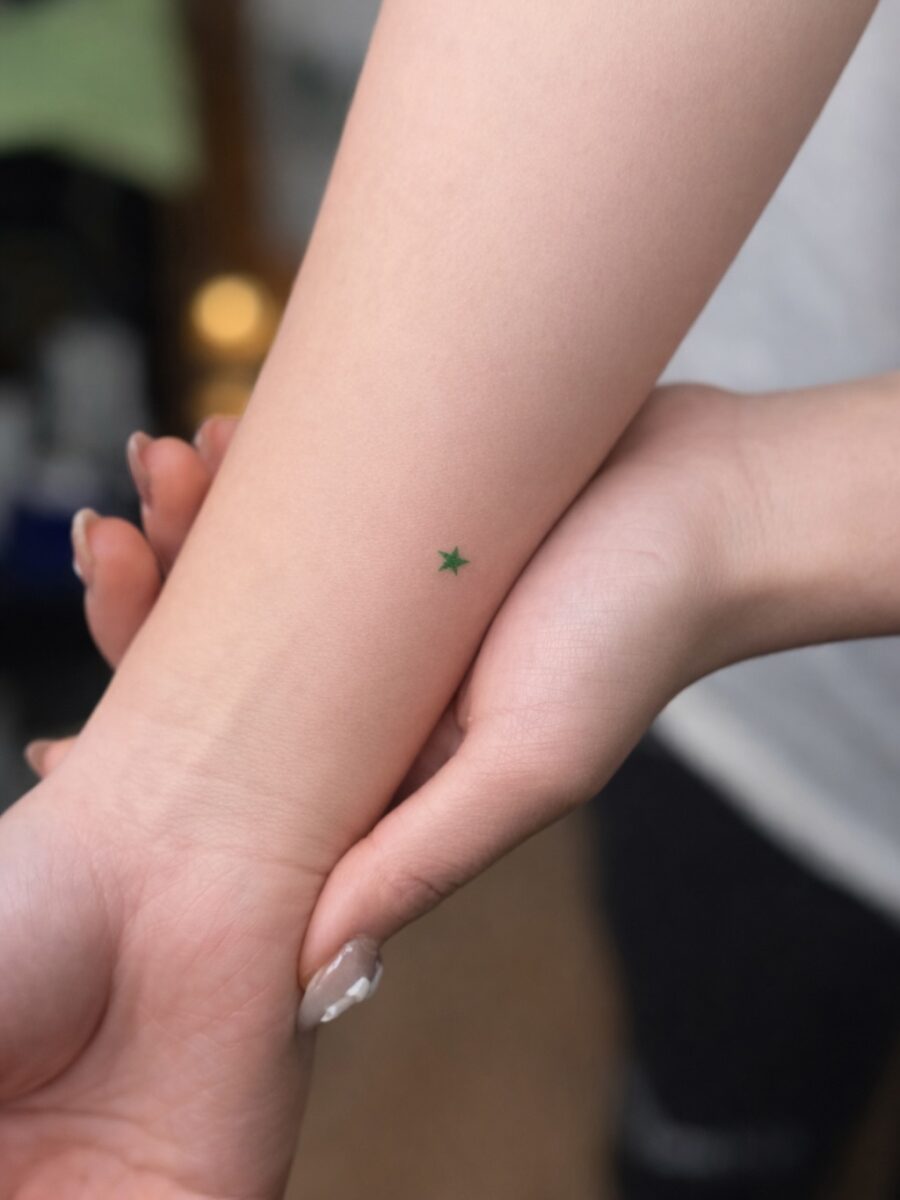 Minimalist green star tattoo on the arm Tattoo on skin