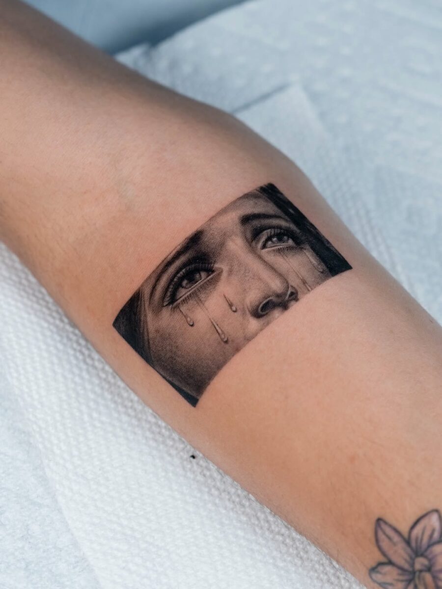 Expressive face tattoo with realistic tears Tattoo on skin