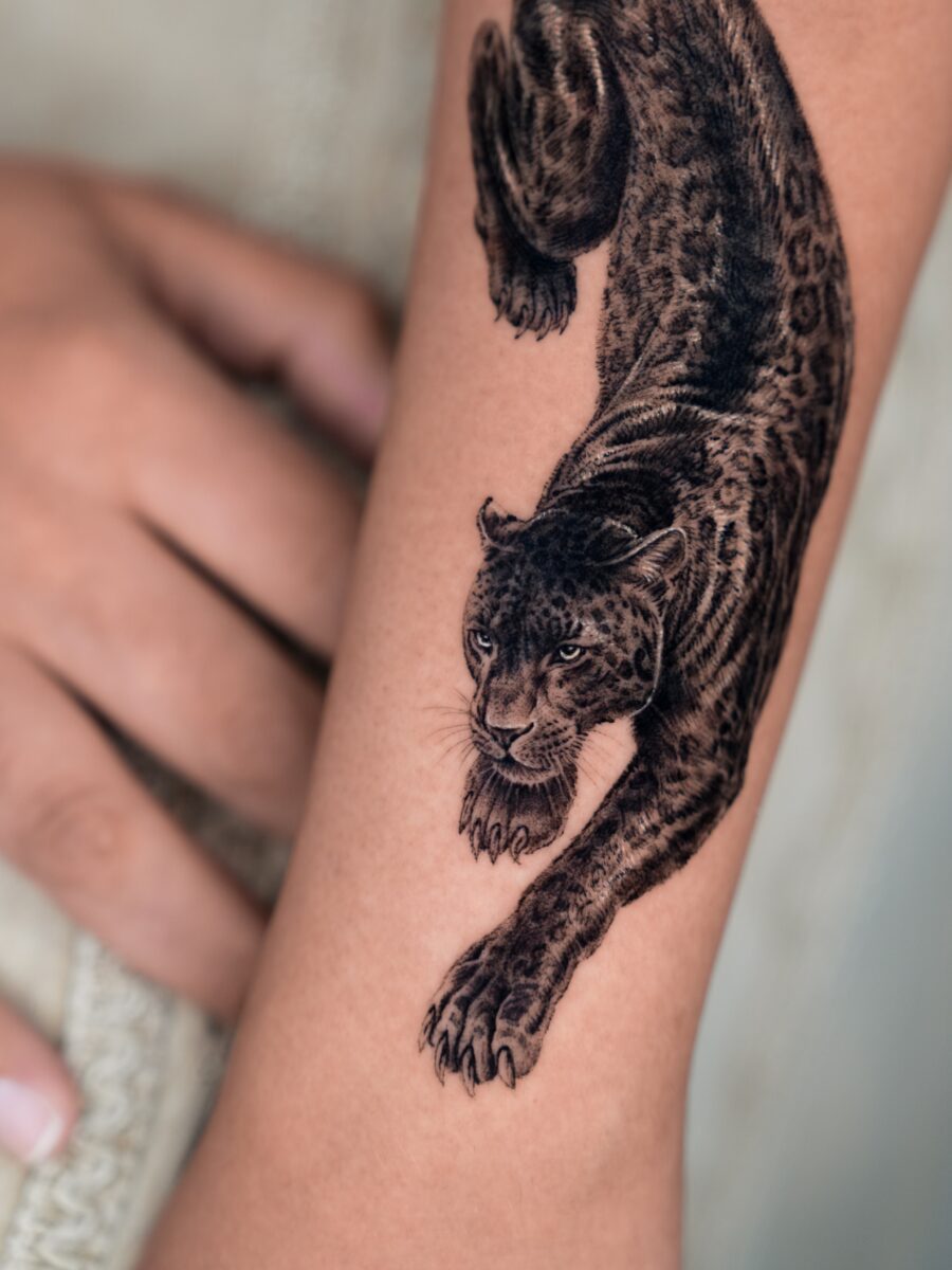 Striking hyper-realistic leopard tattoo design Tattoo on skin