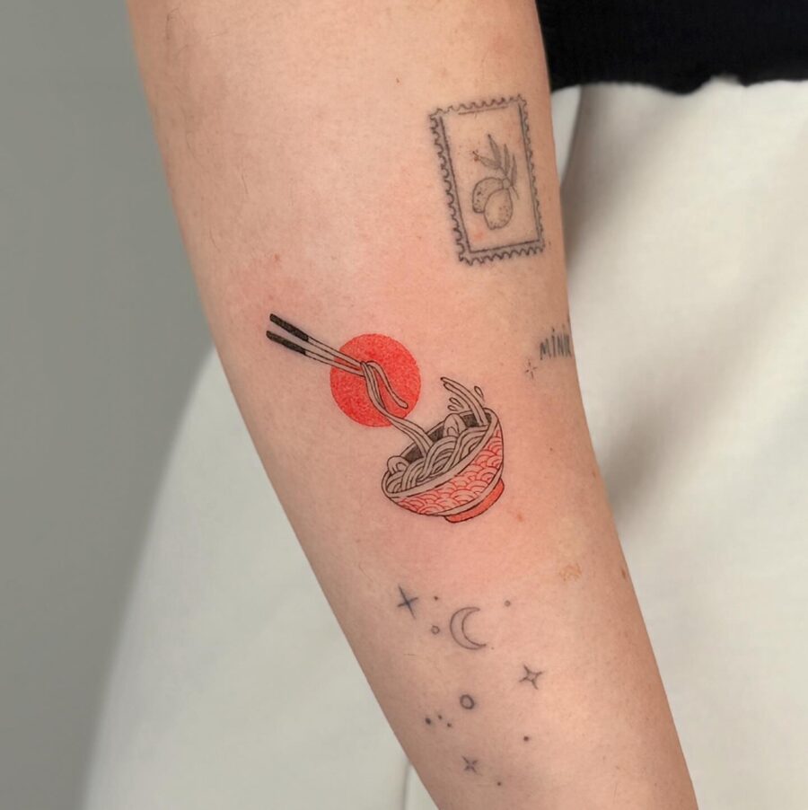Artful noodle bowl with chopsticks and sun Tattoo on skin