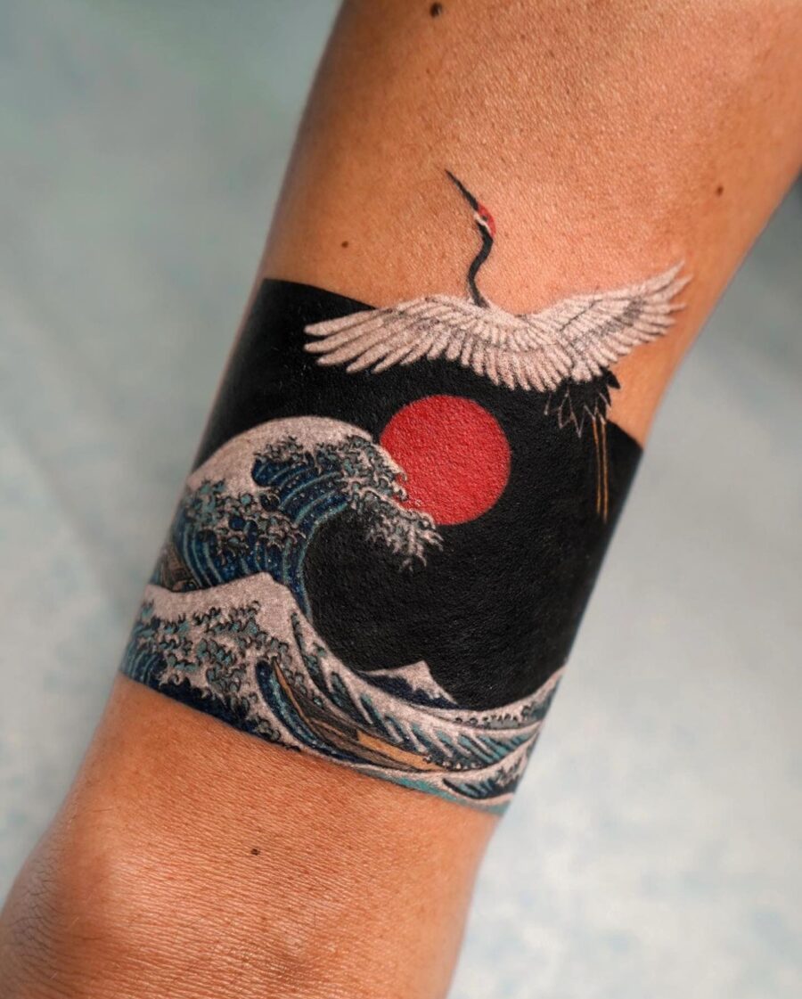 Stunning crane soaring above ocean waves Tattoo on skin