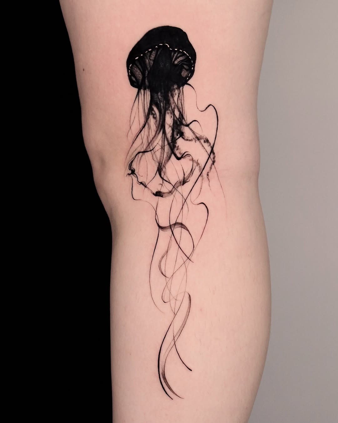 Elegant black jellyfish tattoo on the thigh Tattoo on skin