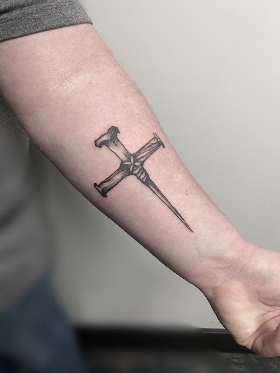Rugged Cross Tattoo with a Nail Base Tattoo on skin