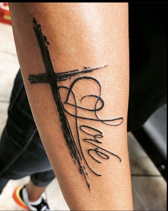 Rugged Cross Tattoo with Cursive “Love” Letters Tattoo on skin