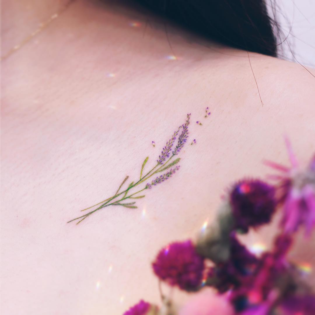 Delicate lavender tattoo on shoulder blossom. Tattoo on skin