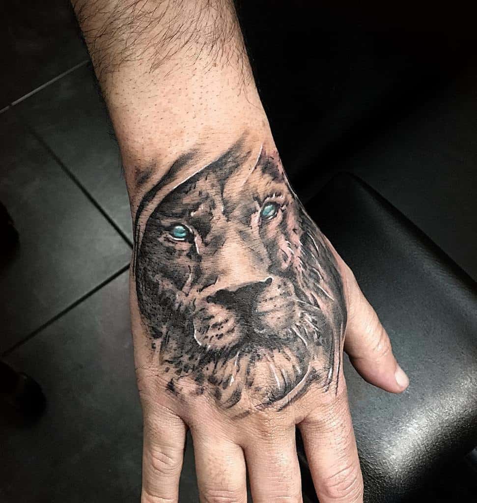 Lion Tattoo Ideas: Blue Eyed Lion Head Tattoo on Hand Tattoo on skin
