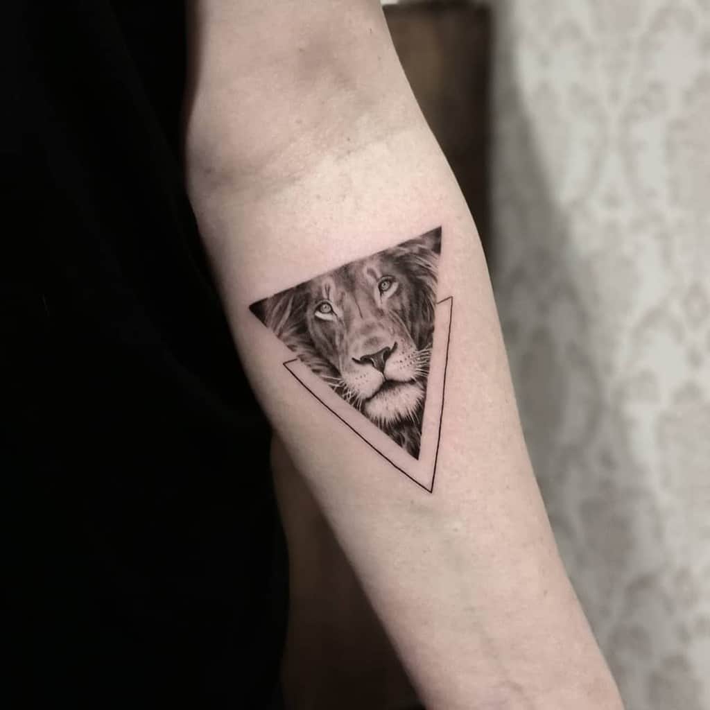 Lion Tattoo Ideas: Lifelike Lion Face in Triangle Tattoo Tattoo on skin