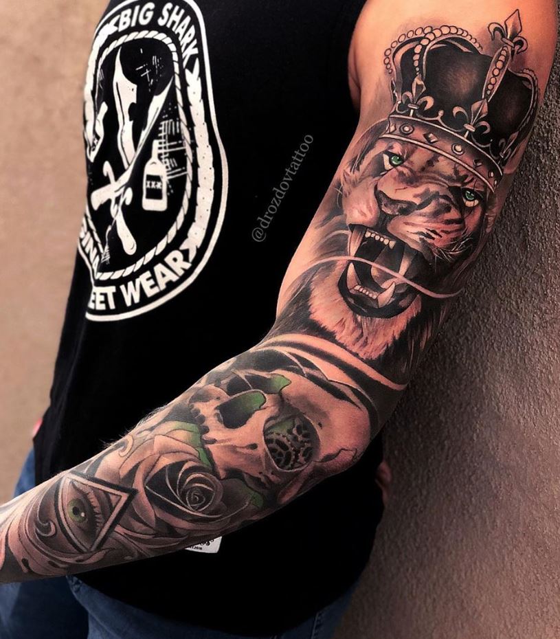 Lion Tattoo Ideas: Roaring Lion with Crown Arm Tattoo Tattoo on skin