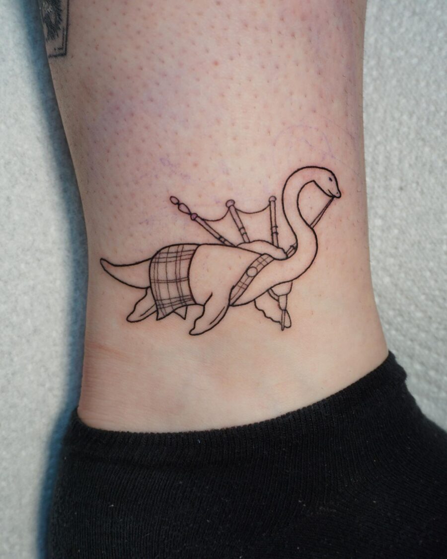 Charming Loch Ness Monster Tattoo with Bagpipes Tattoo on skin