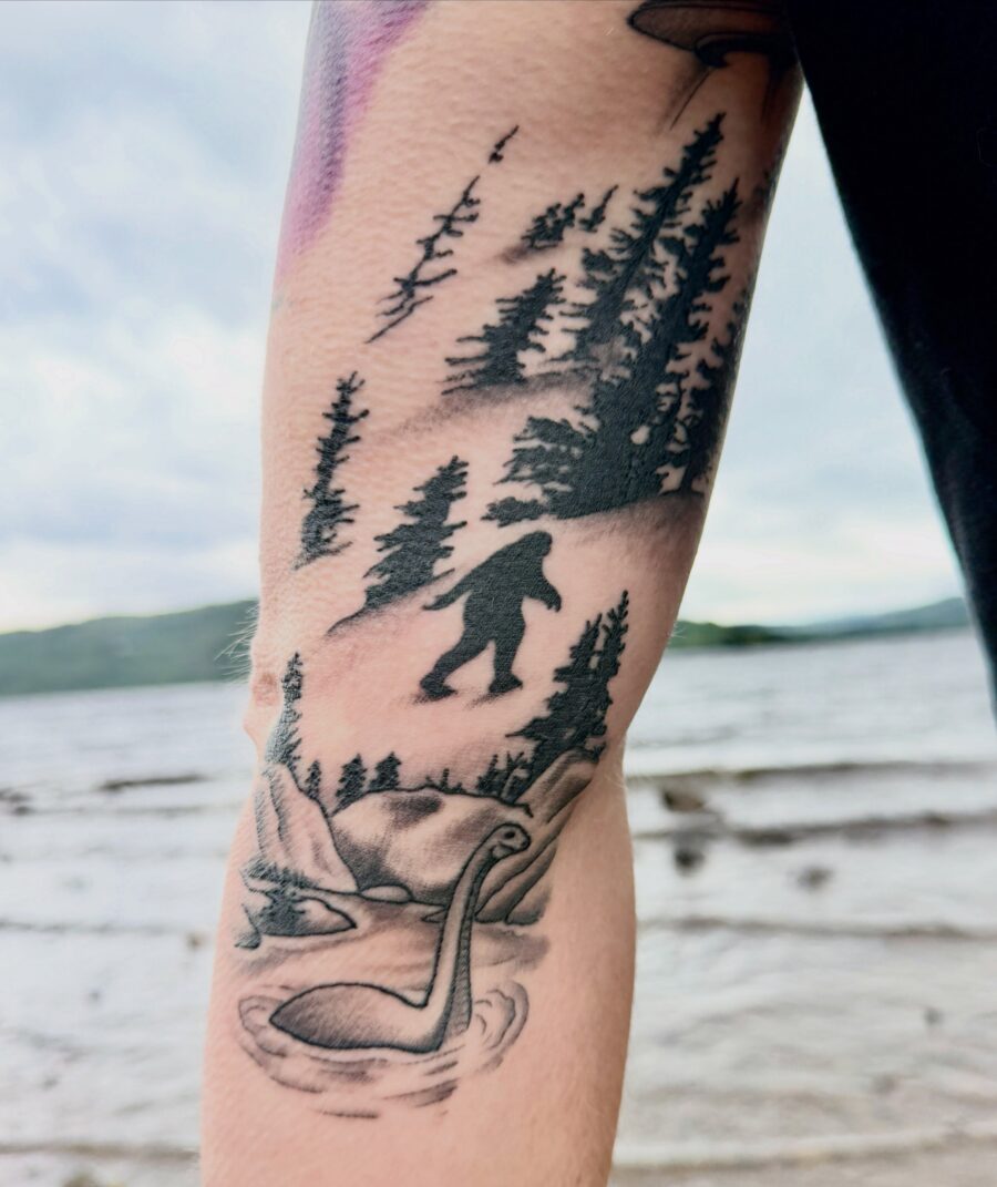 Intricate Loch Ness Monster Tattoo with Forest Scene Tattoo on skin