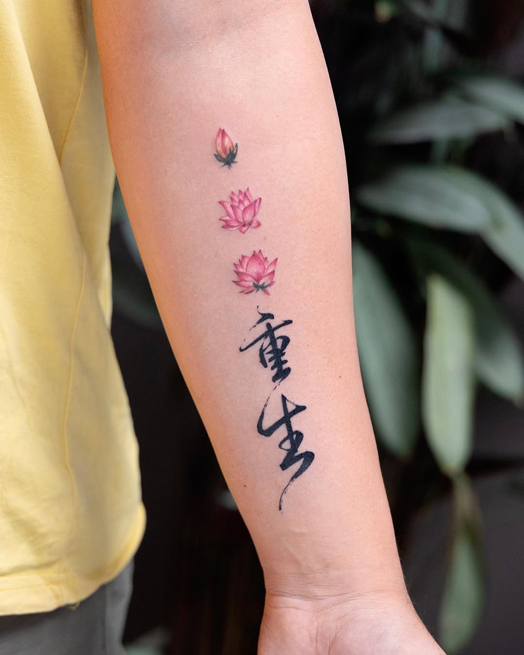 Elegant lotus blooms with meaningful script decoration Tattoo on skin