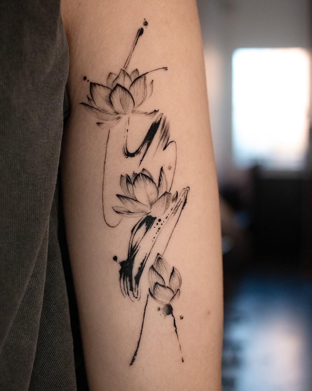 Elegant lotus tattoo with flowing black lines Tattoo on skin