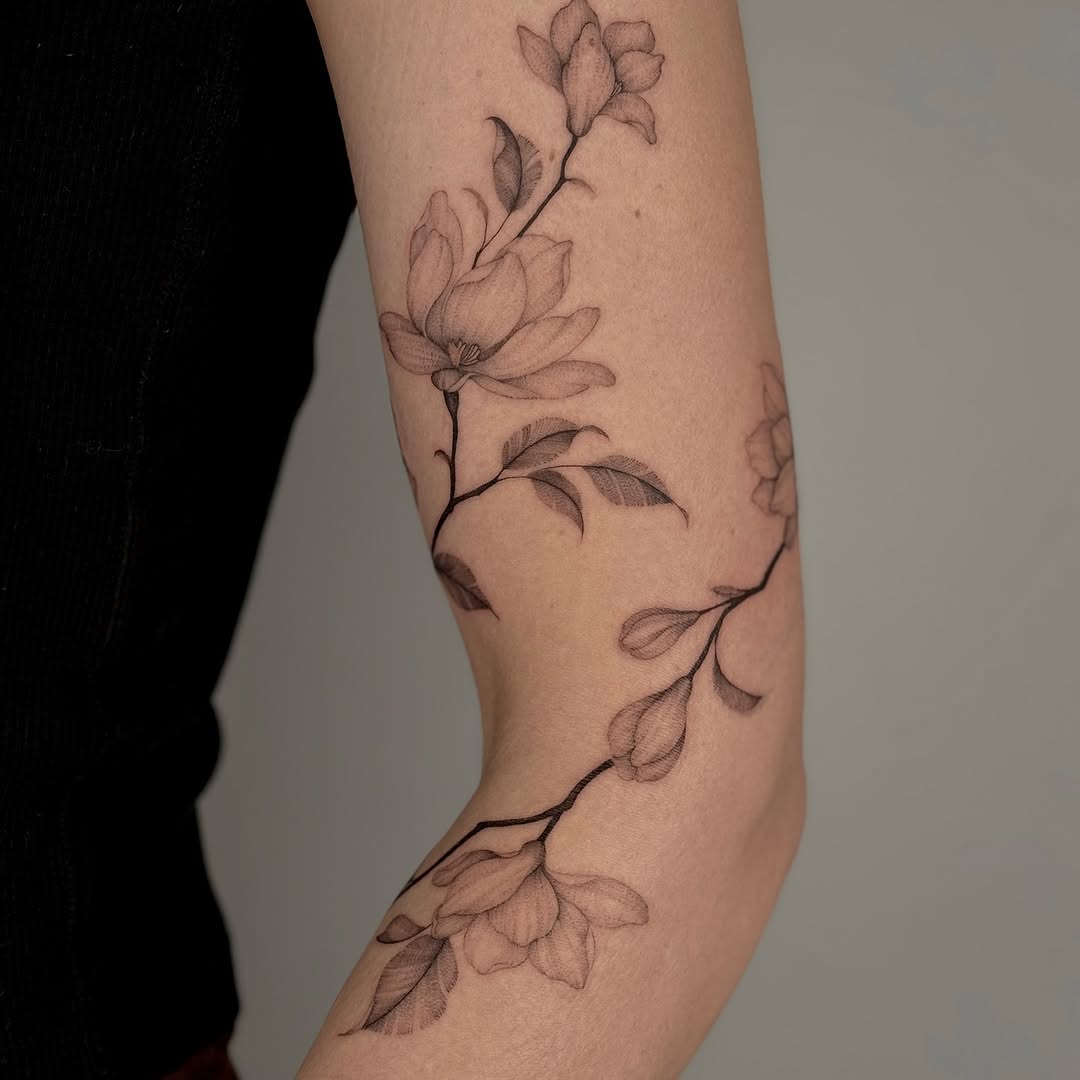 Elegant floral design wraps around the elbow Tattoo on skin