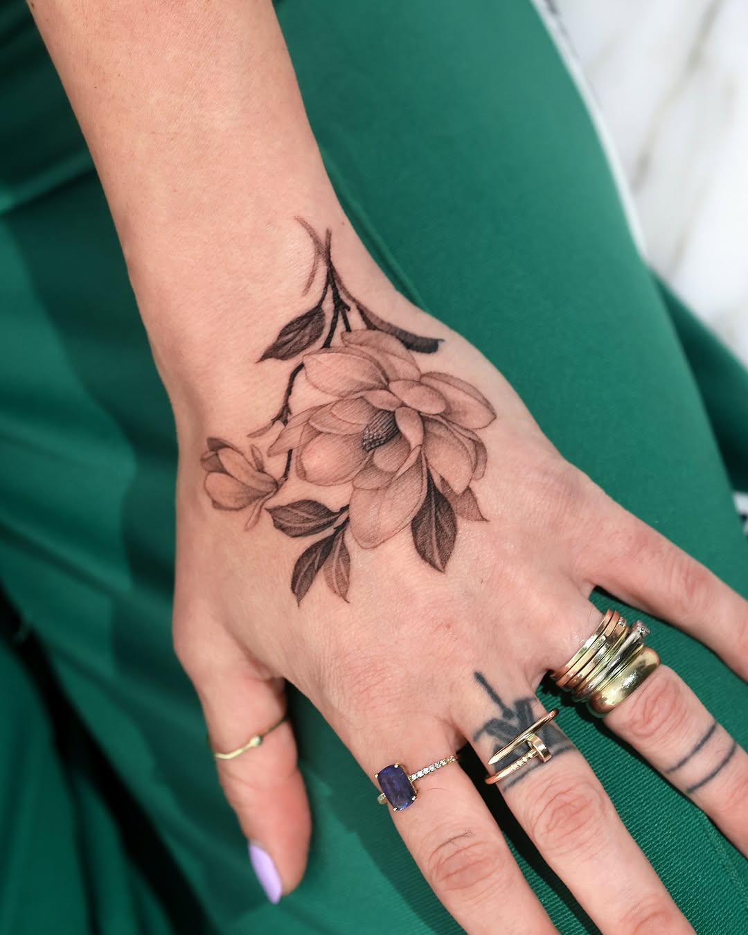 Elegant magnolia tattoo adorning the hand Tattoo on skin