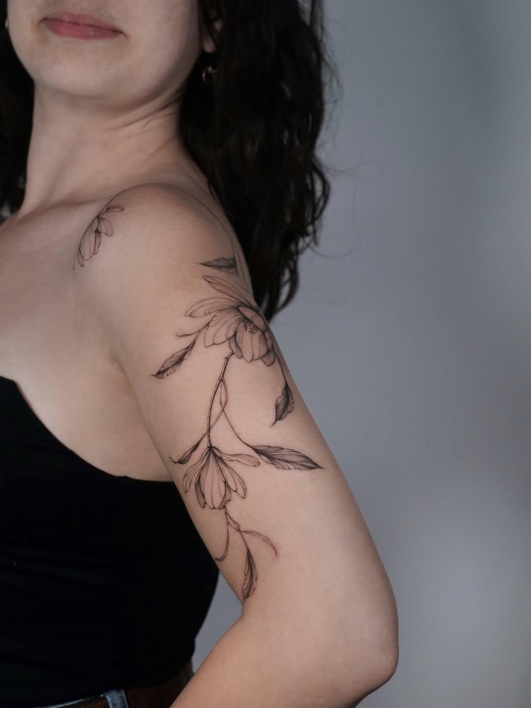 Elegant magnolia tattoo on feminine arm. Tattoo on skin