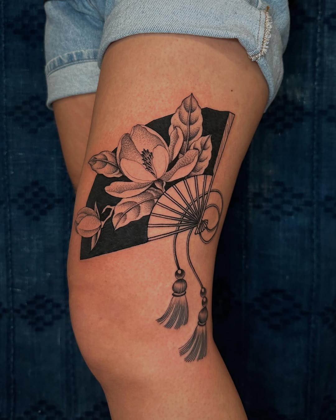 Elegant magnolia tattoo with fan motif Tattoo on skin