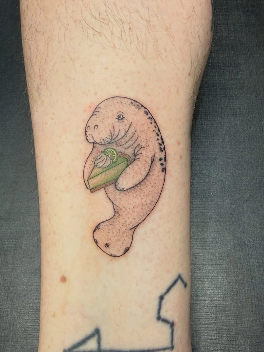 Adorable manatee tattoo with a slice of cake Tattoo on skin