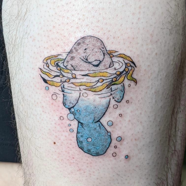 Charming manatee in vibrant aquatic swirls Tattoo on skin