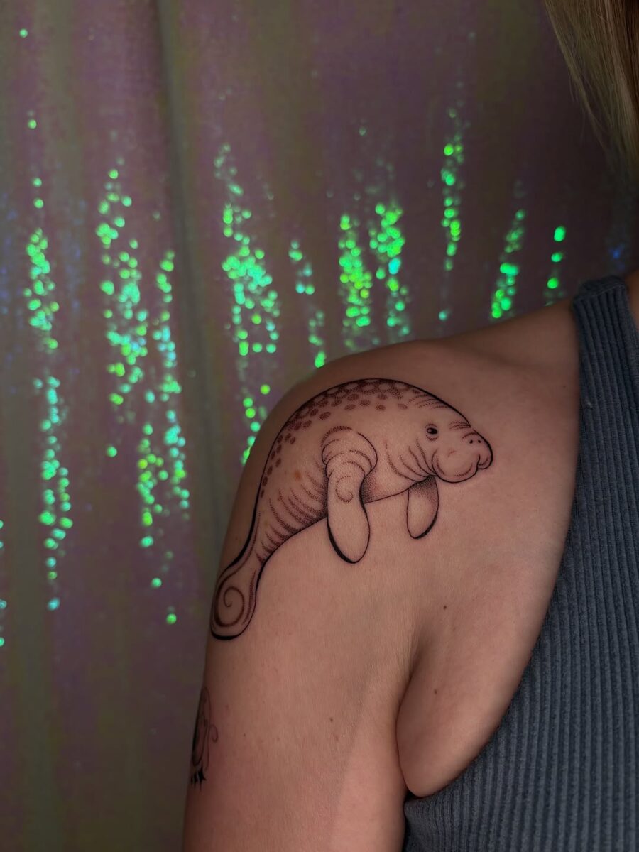 Charming manatee tattoo on shoulder Tattoo on skin