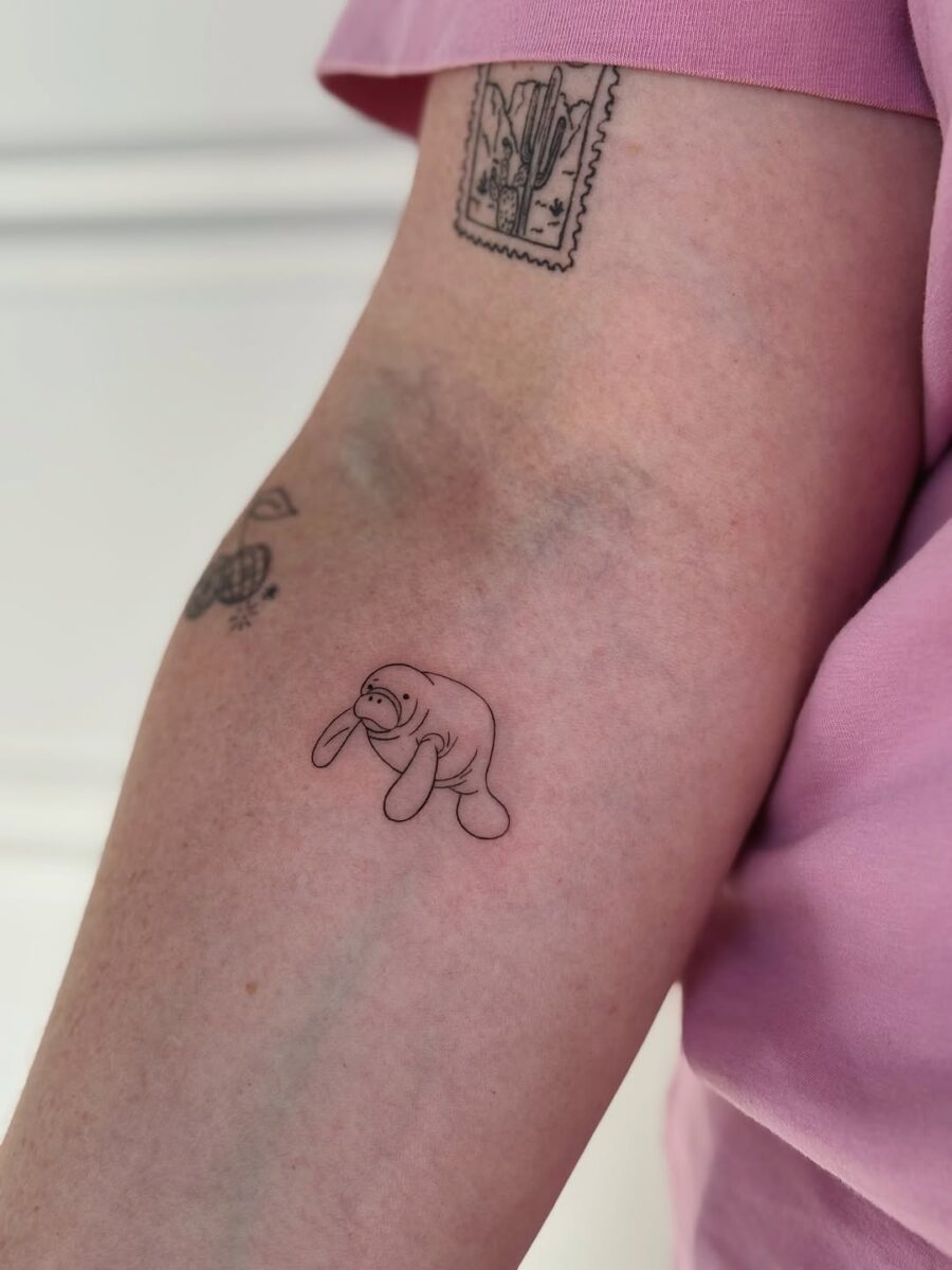 Charming minimalist manatee tattoo on arm Tattoo on skin