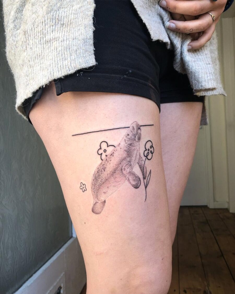 Whimsical manatee tattoo on the thigh Tattoo on skin