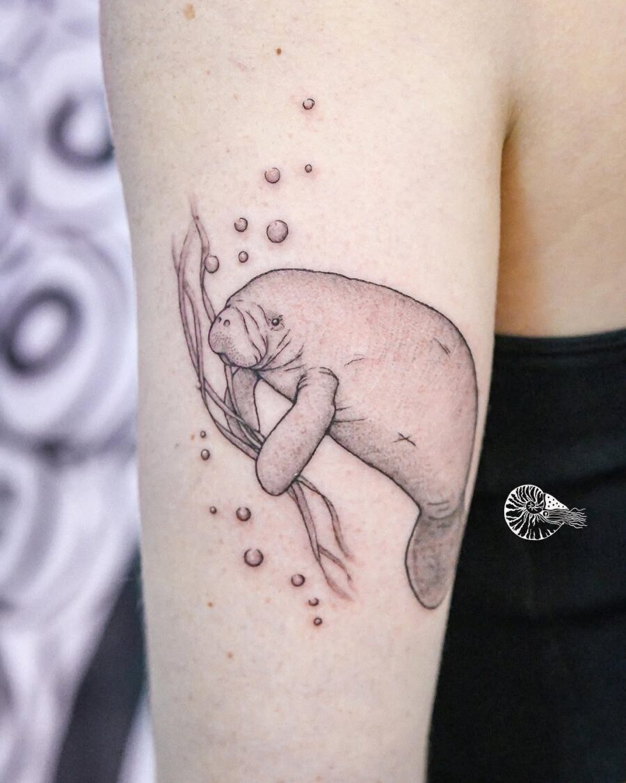 Whimsical manatee tattoo showcasing aquatic charm Tattoo on skin