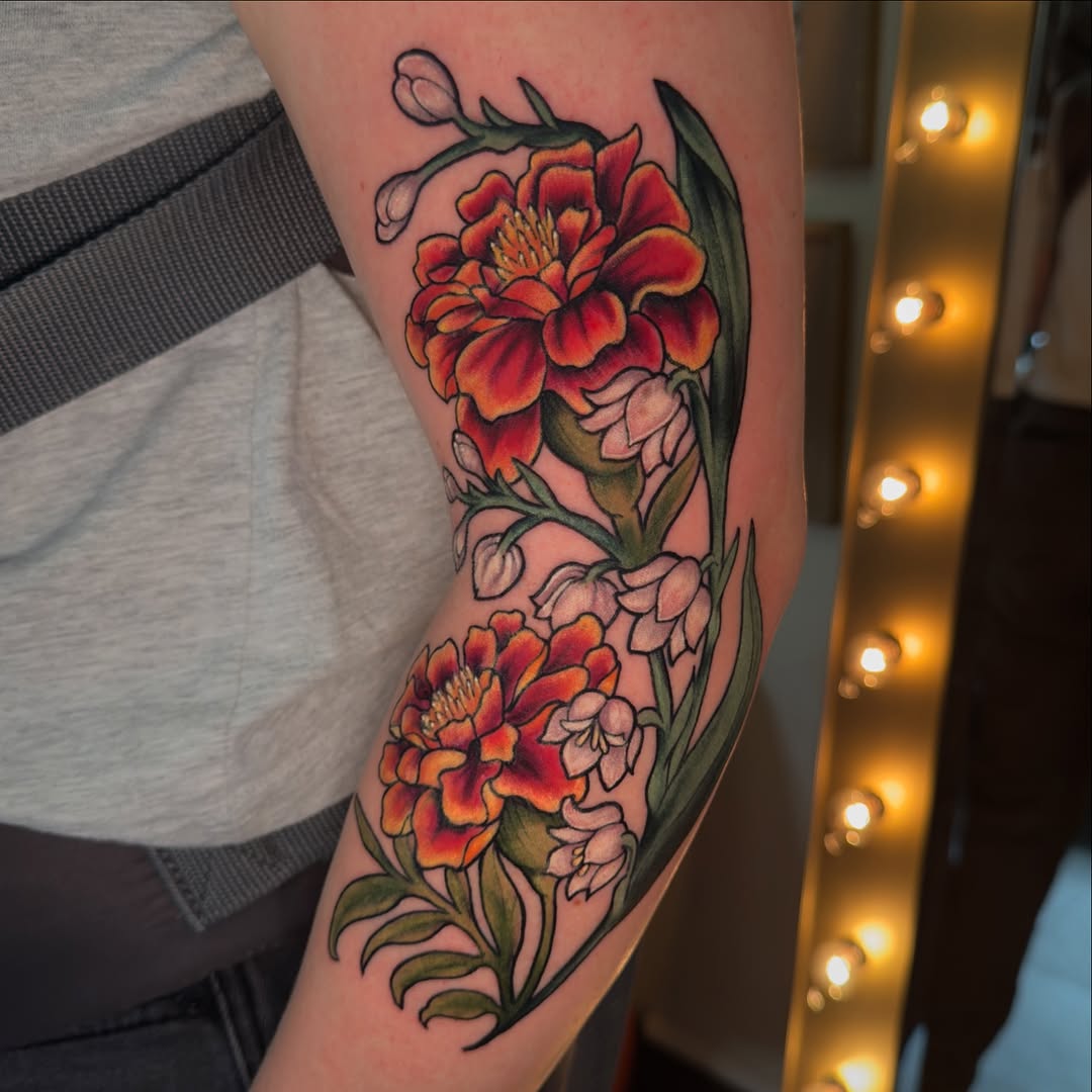 Bright marigold tattoo with floral accents Tattoo on skin