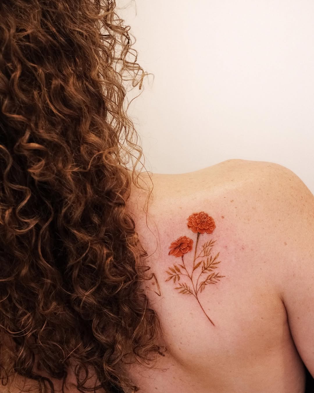 Elegant marigold tattoo on shoulder area Tattoo on skin