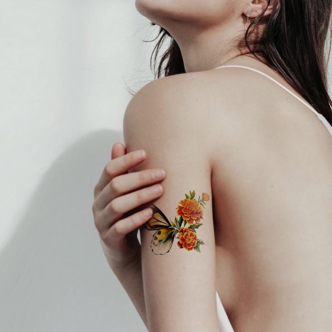 Stunning marigold tattoo with butterfly accent Tattoo on skin
