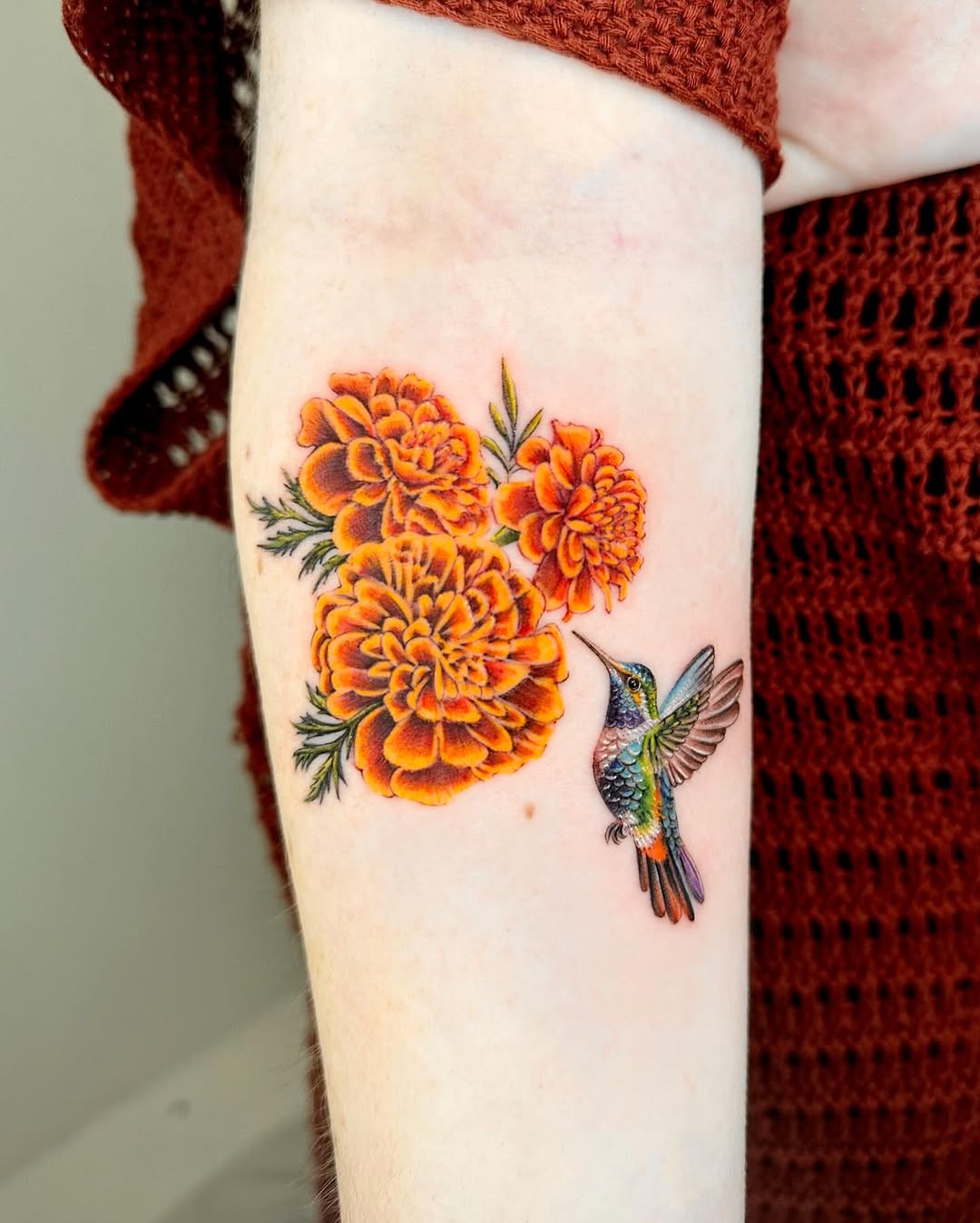 Stunning marigold tattoo with hummingbird Tattoo on skin