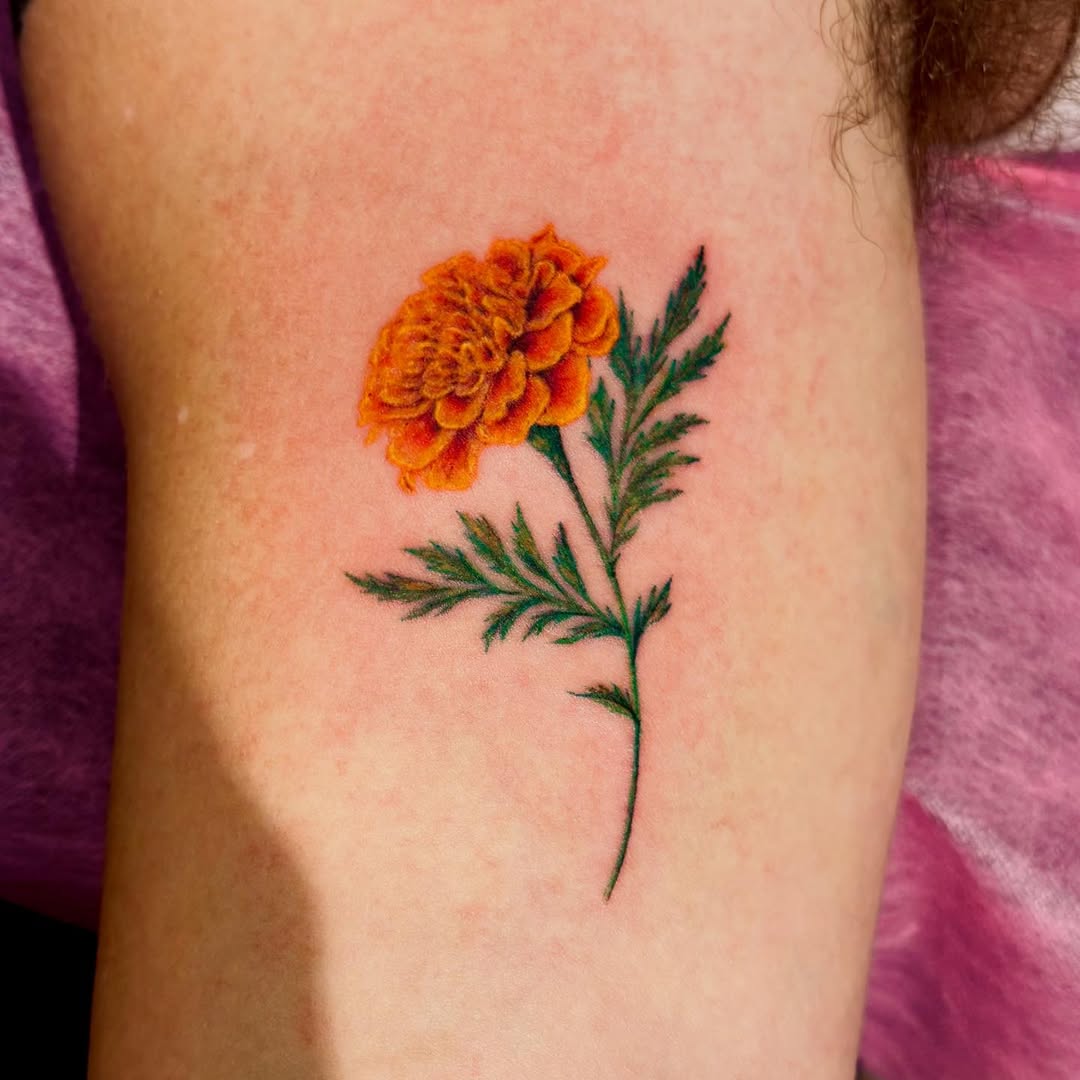 Stunning marigold tattoo with striking colors Tattoo on skin