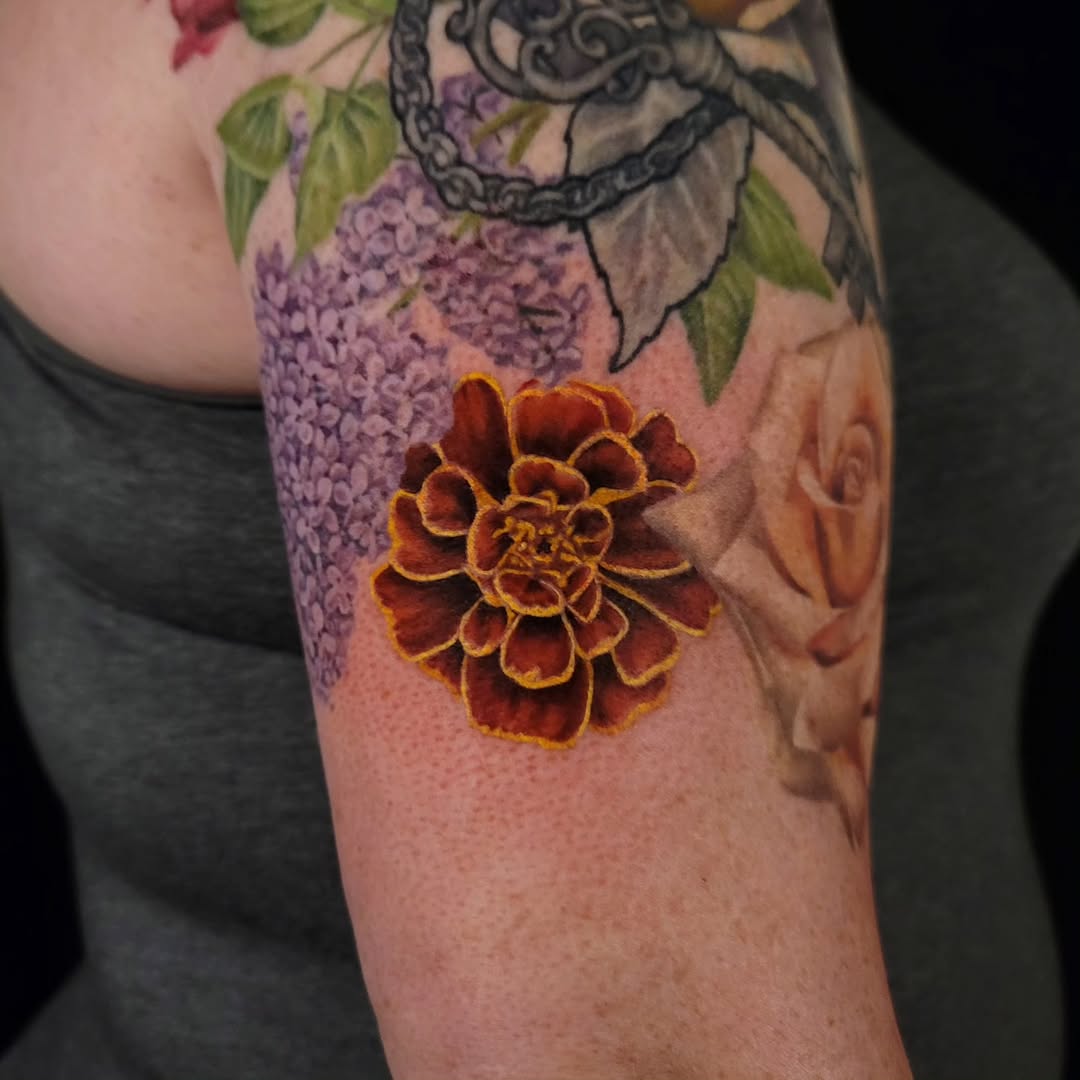 Vibrant marigold flower tattoo in full bloom Tattoo on skin