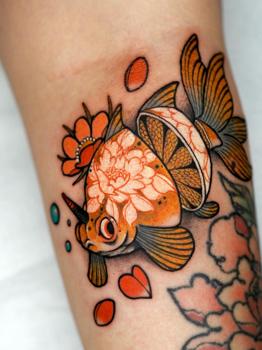 Whimsical goldfish tattoo with floral accents Tattoo on skin