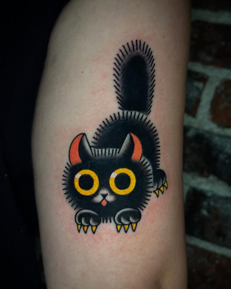 Playful black cat tattoo with vibrant colors Tattoo on skin