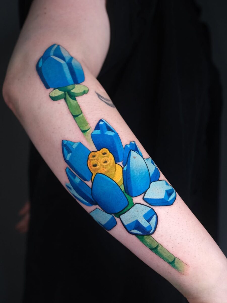 Vibrant lotus flower tattoo with playful elements Tattoo on skin