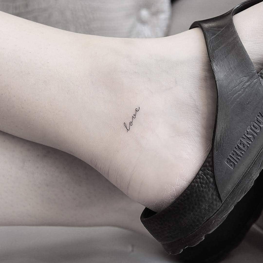 Delicate ankle tattoo showcasing the word 'love' Tattoo on skin