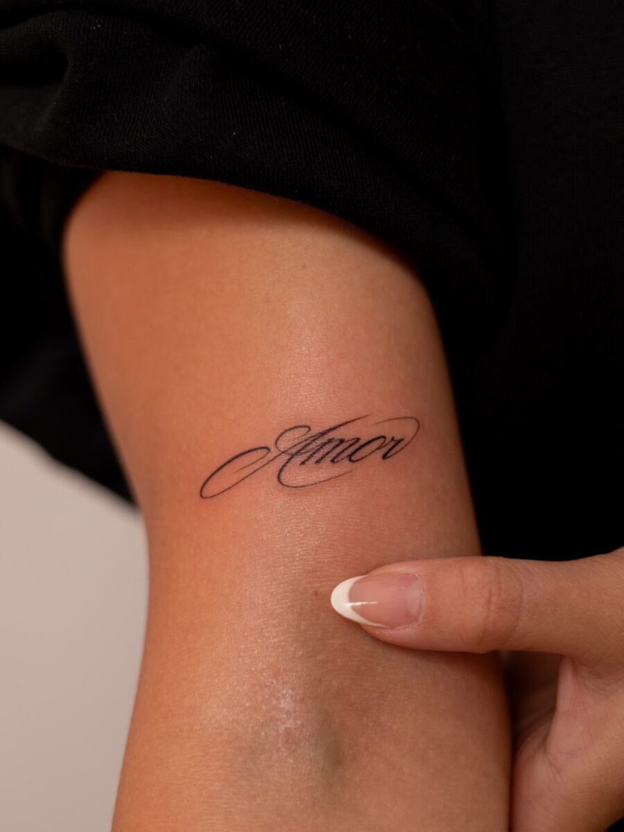 Elegant one-word tattoo showcasing love's essence Tattoo on skin