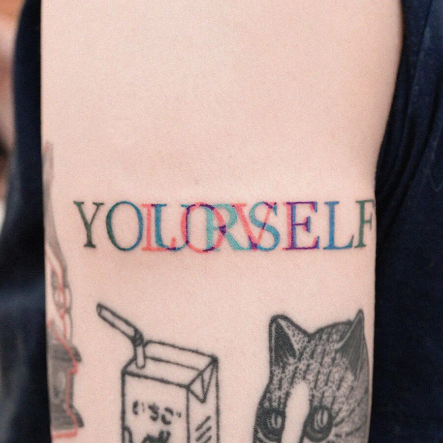 Colorful tattoo emphasizing self-love and identity Tattoo on skin