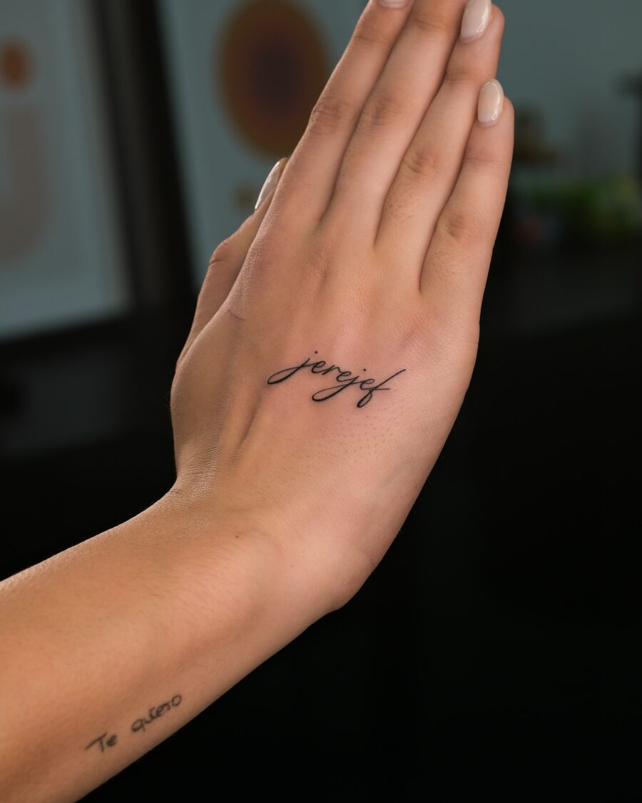 Elegant and minimalist one-word tattoos on hand Tattoo on skin