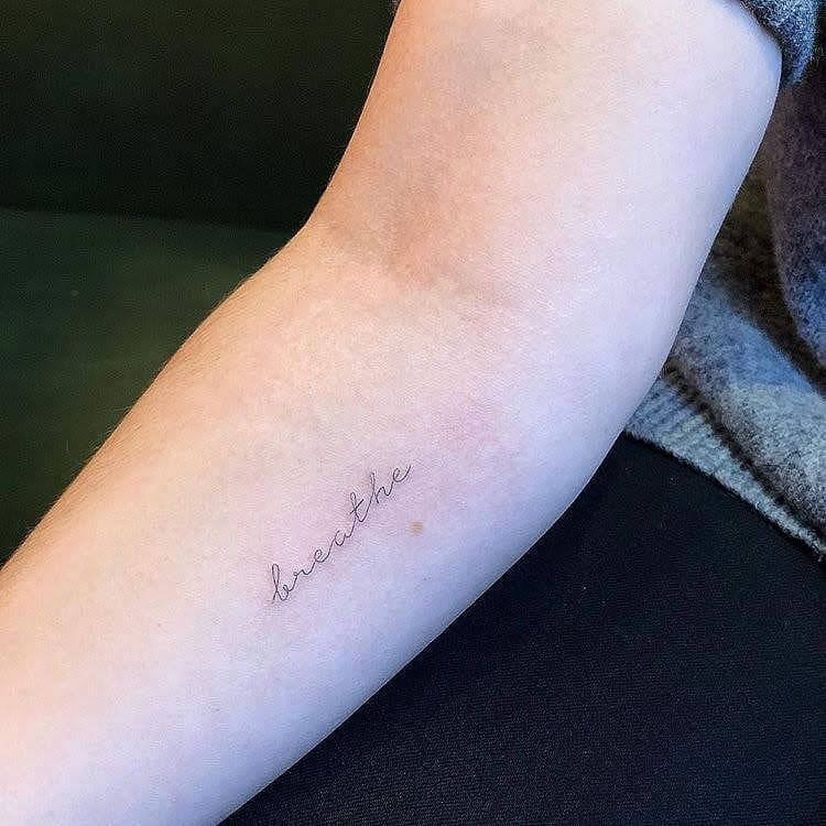 Elegant one-word tattoo for mindfulness Tattoo on skin