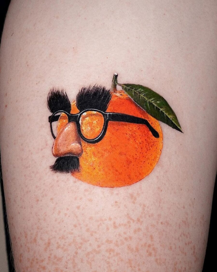 A quirky orange tattoo with personality. Tattoo on skin
