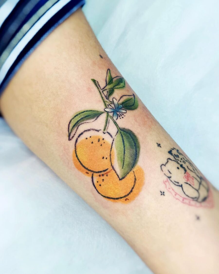 Charming orange tattoo with vibrant leaves Tattoo on skin