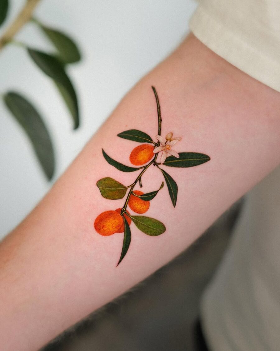 Elegant orange branch tattoo on the forearm Tattoo on skin