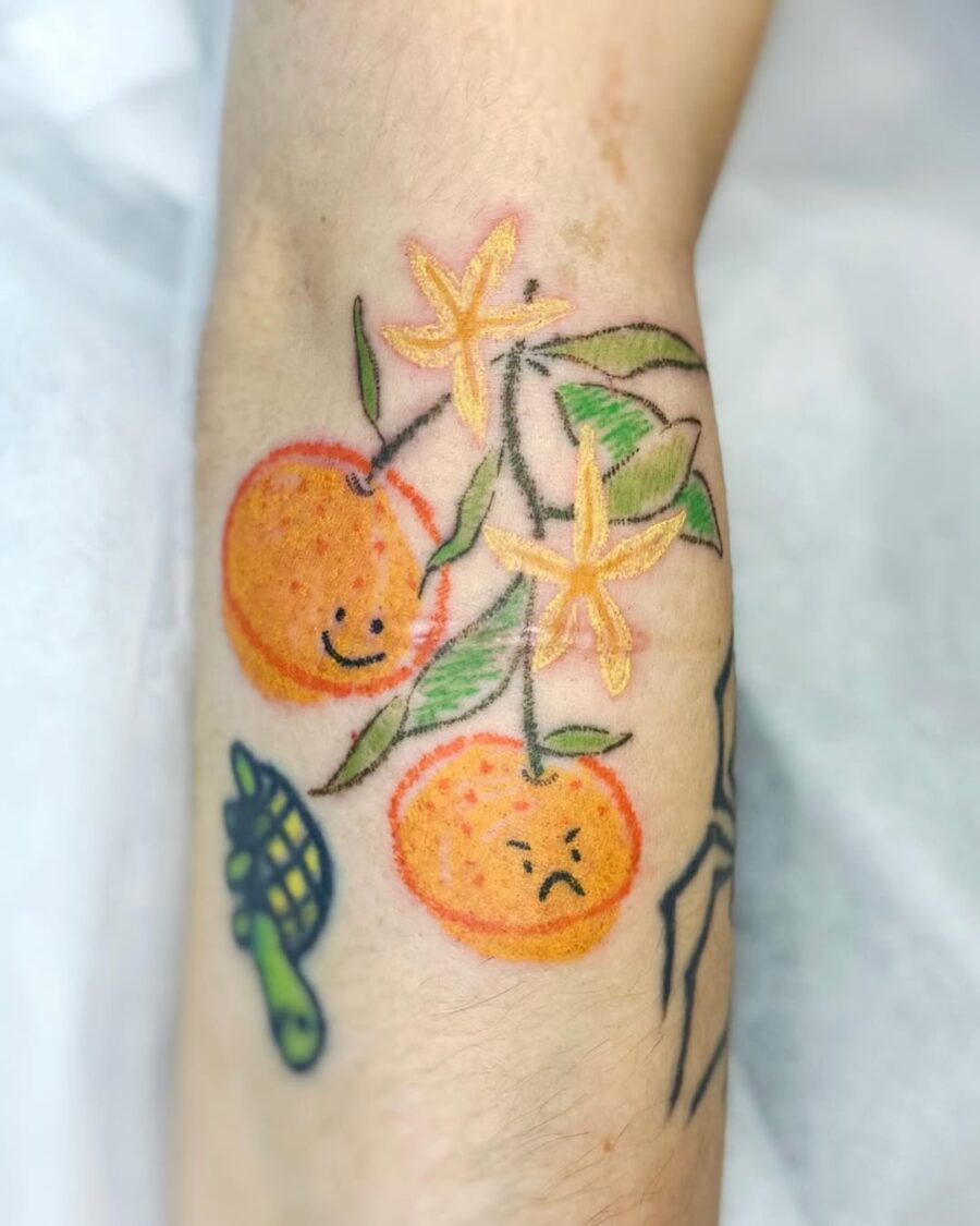 Playful orange tattoos with mixed emotions Tattoo on skin