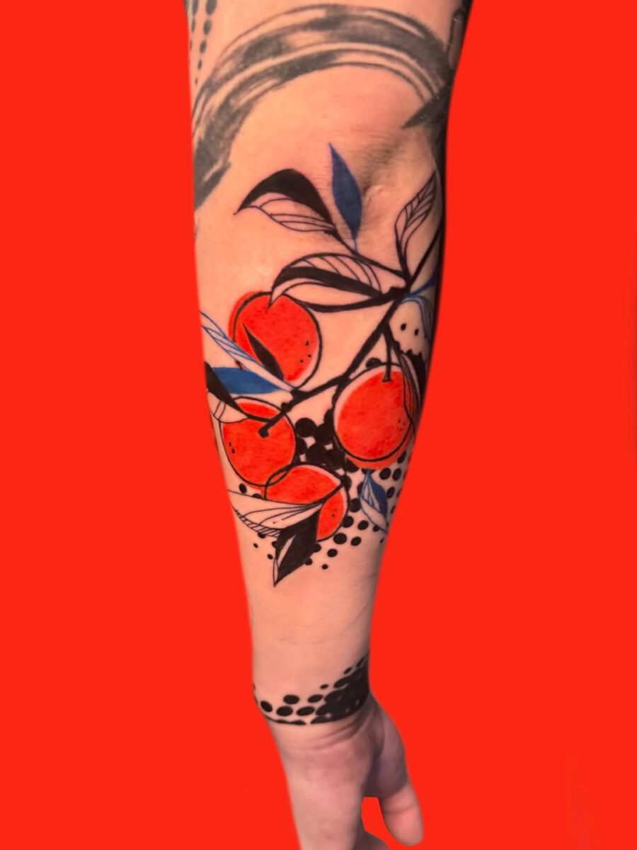 Vibrant orange fruit tattoo with bold foliage orange tattoos